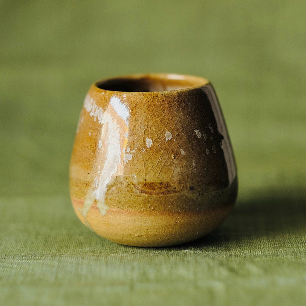 A close shot of a Tamago mug by 22tutucraft on a green table clothe