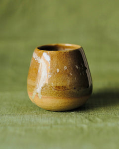 A close shot of a Tamago mug by 22tutucraft on a green table clothe