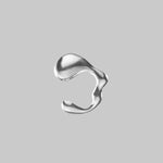 a wavy silver colored ear cuff on a light gray background